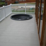 White ballustrade with stone deck boards with round hot tub